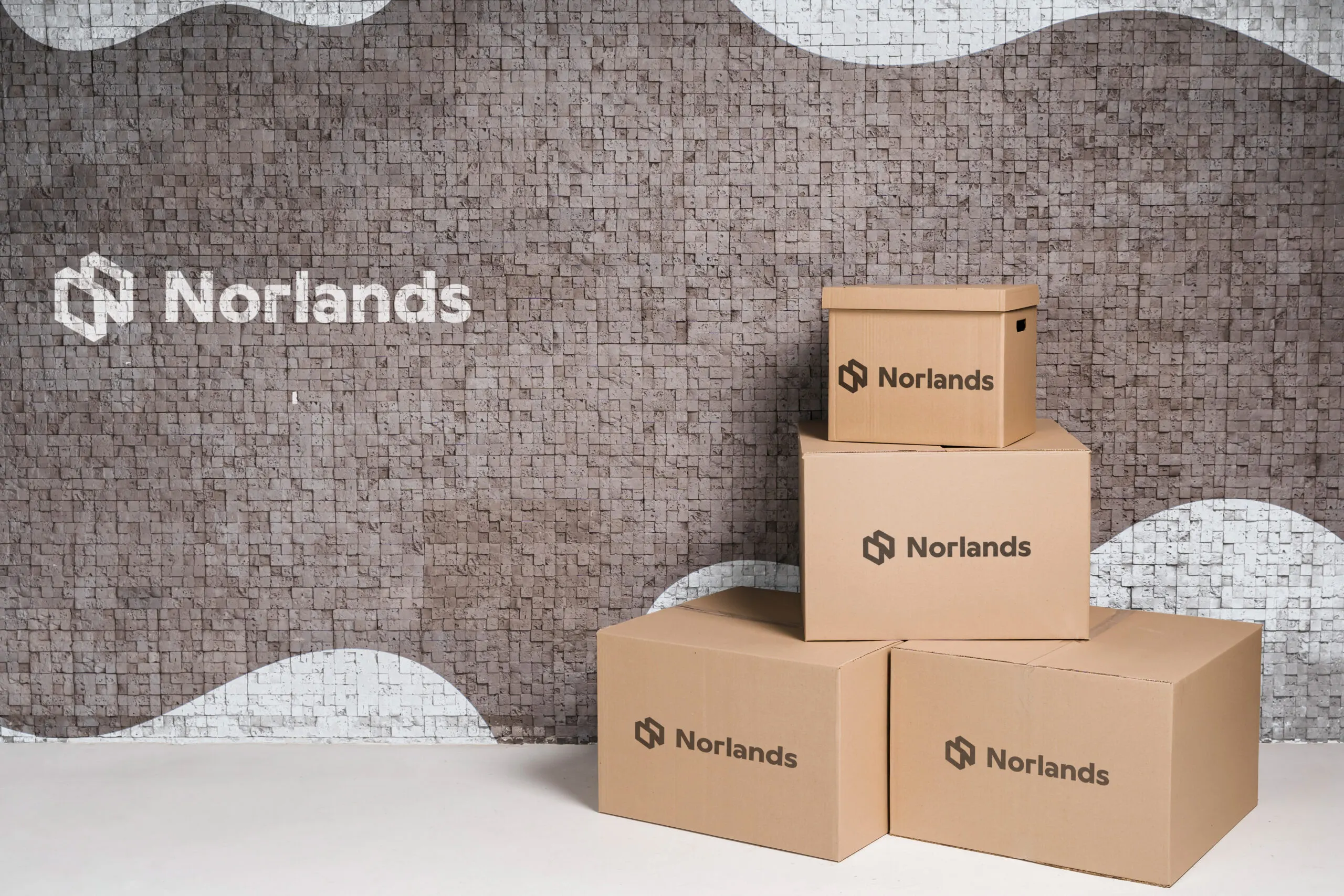Buy Moving Boxes in Vancouver- A stack of Norlands-branded cardboard boxes arranged neatly against a modern tiled wall, showcasing durability and minimalist packaging design.