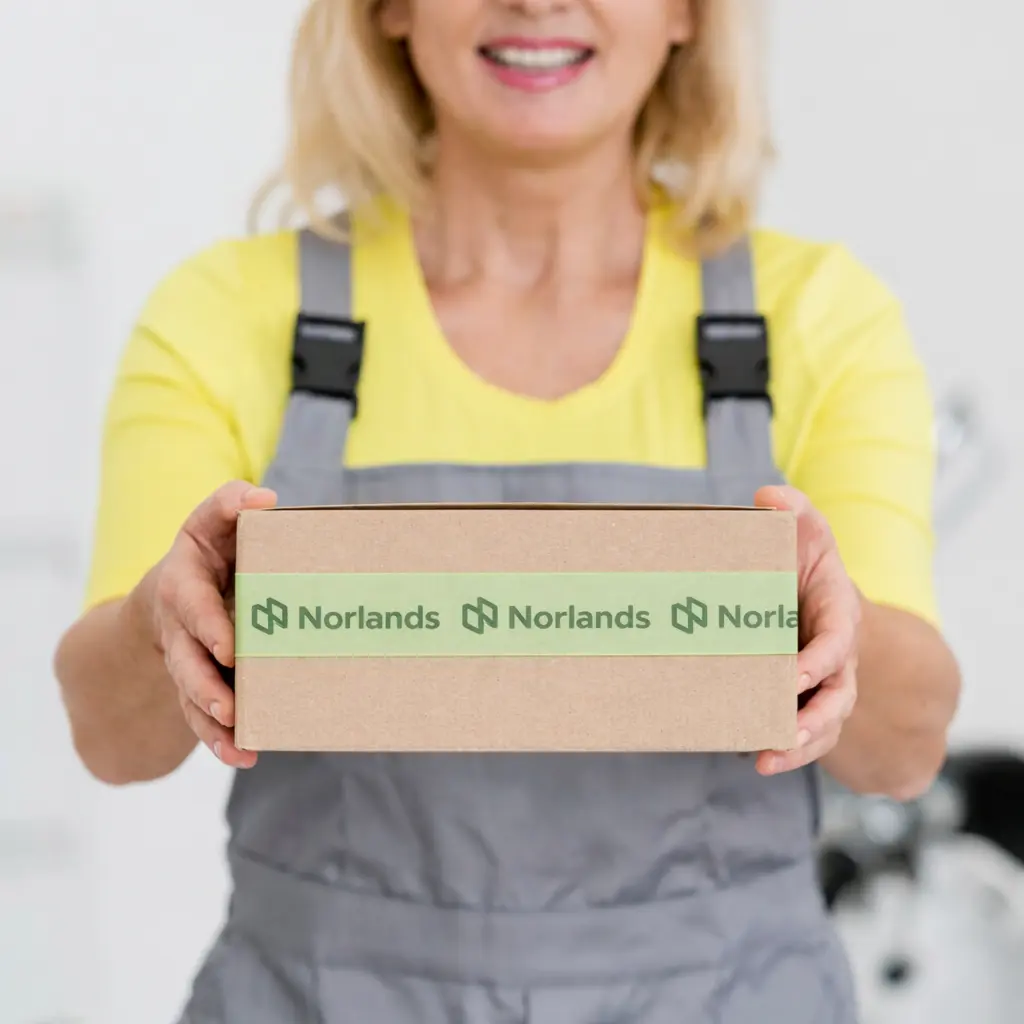 Worker holding a packaged corrugated box illustrating how businesses manage packaging delays Western Canada through reliable packaging supply