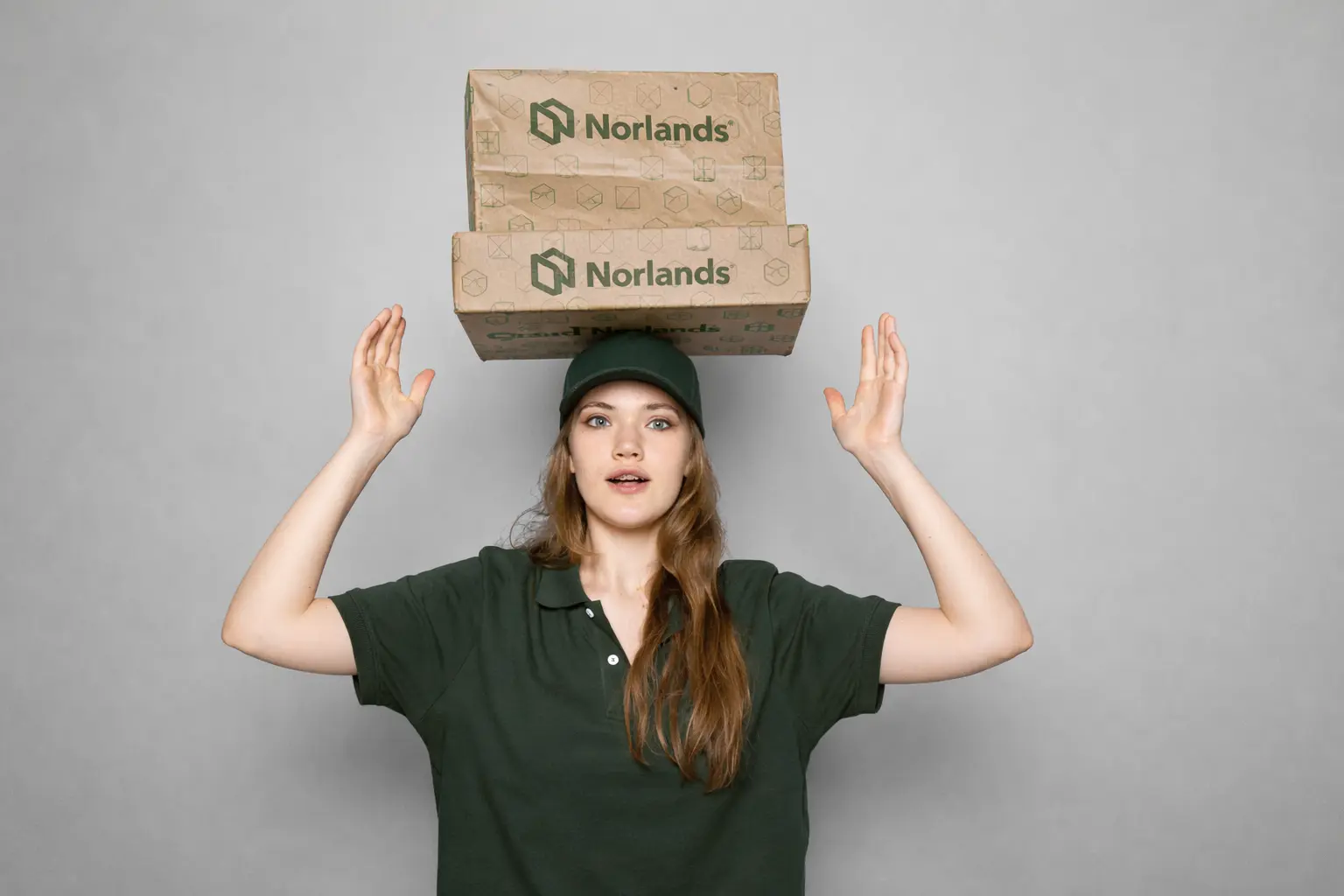 Delivery worker balancing stacked shipping boxes representing operational challenges related to packaging delays Western Canada in distribution logistics
